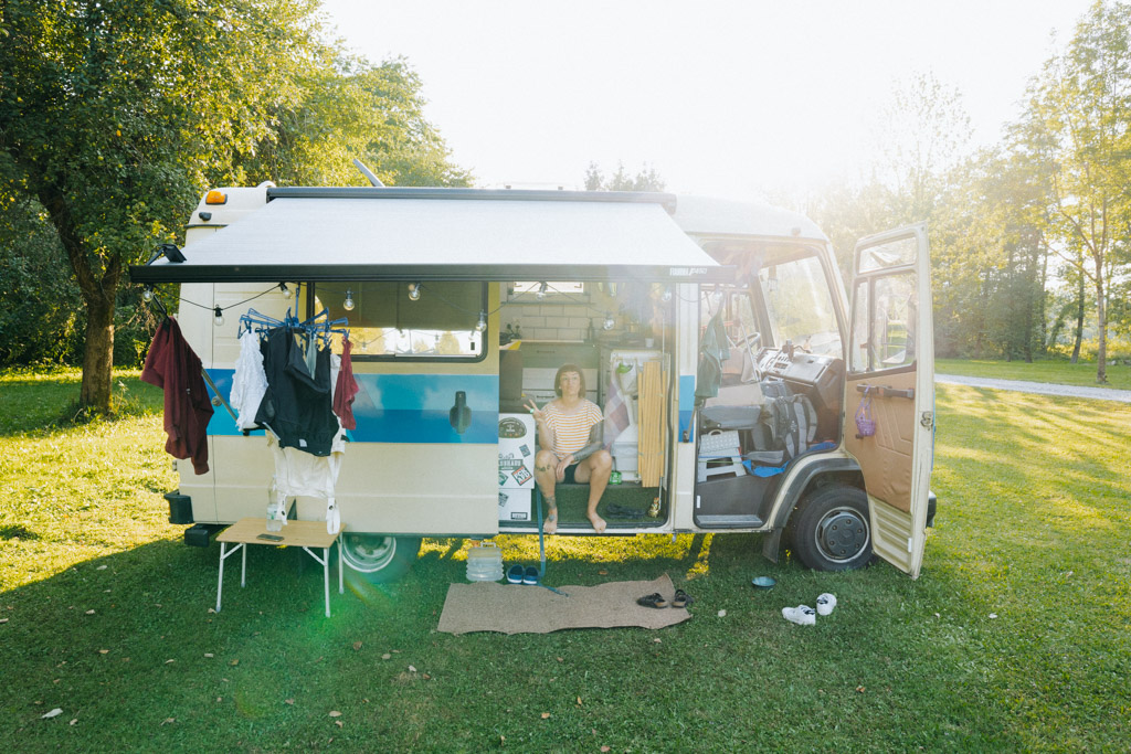 Lisa Ludwig sitzt im Campervan Mercedes Benz Hubi auf dem Stellplatz in Slowenien Kamp Savinja, dem schönsten Campingplatz in Slowenien