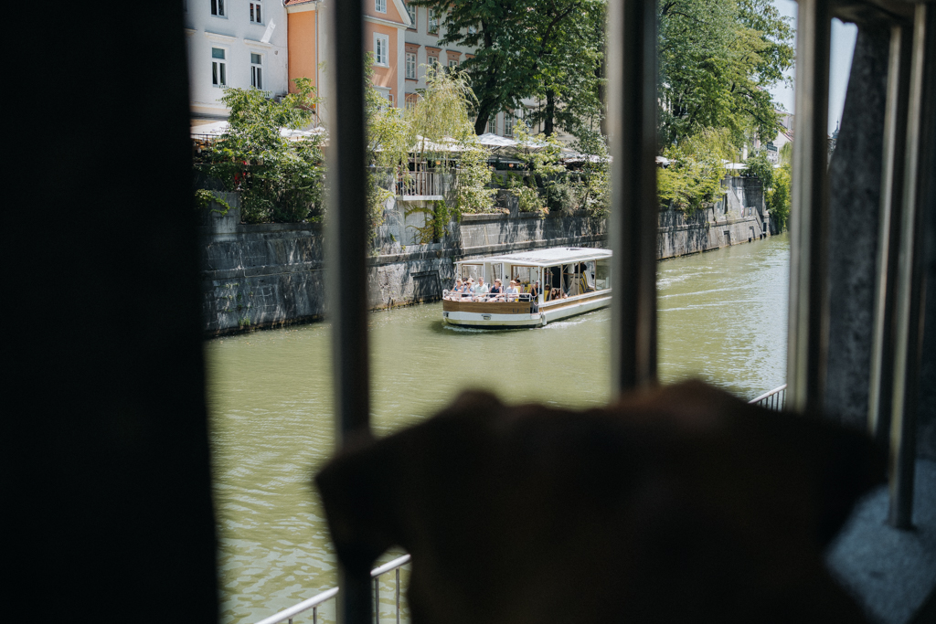 Frau Maier beobachtet die Boote auf der Ljubljanica in Ljubljana 